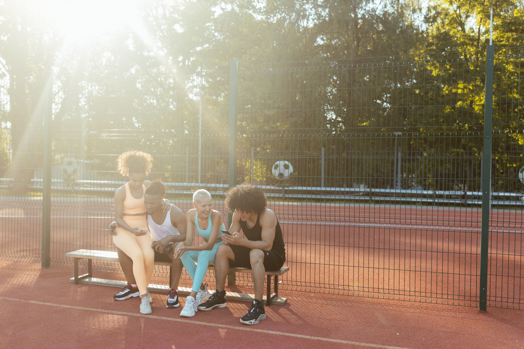 Friends sharing a moment beside a sports court — illustrative stock photography