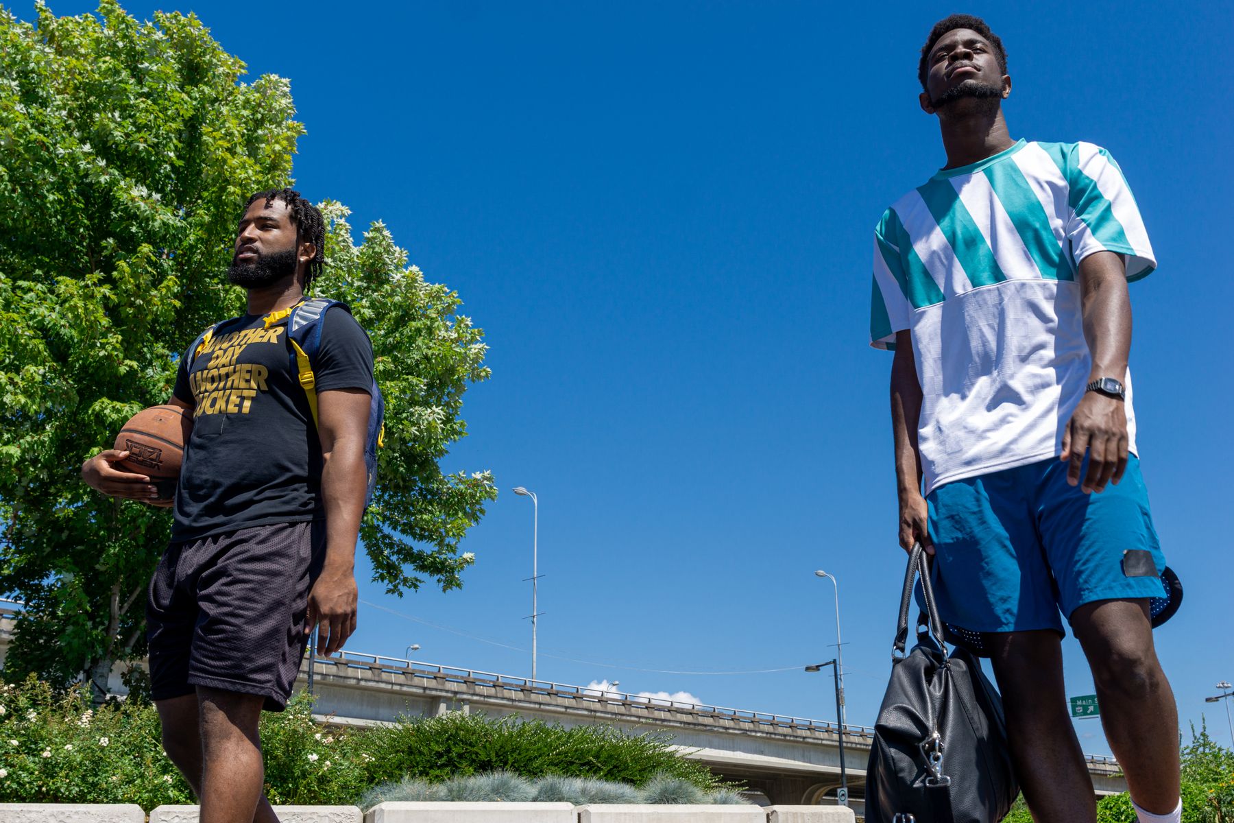Two players arriving with a basketball beneath blue sky — illustrative stock photograph, not the fictional interview or club