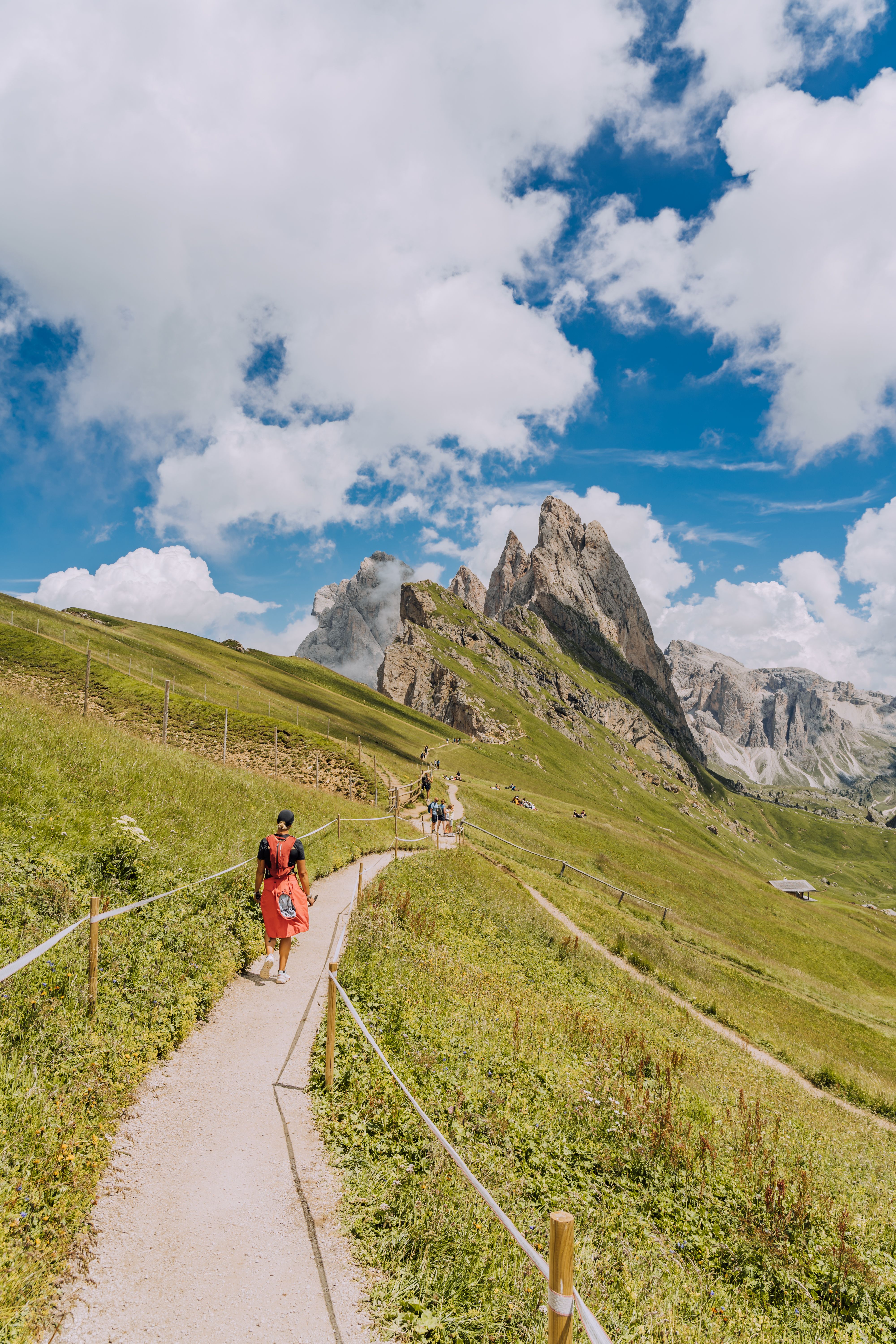 Hikers on a trail beneath the Dolomites